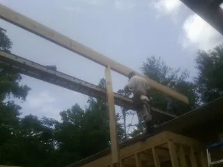 Carpenter setting a ridge beam over a new addition frame — Ice Dam Removal by Roofing Brothers in Mansfield Center