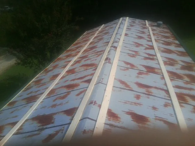 Rusted metal roof panels with new wood purlins before replacement — Storm Damage Roof Repair in Mansfield Center by Roofing Brothers