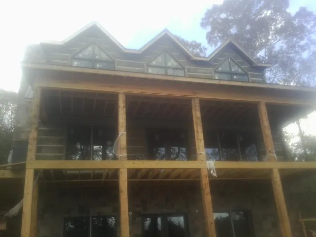 Dormers and porch framing on a large log home under construction in Mansfield Center