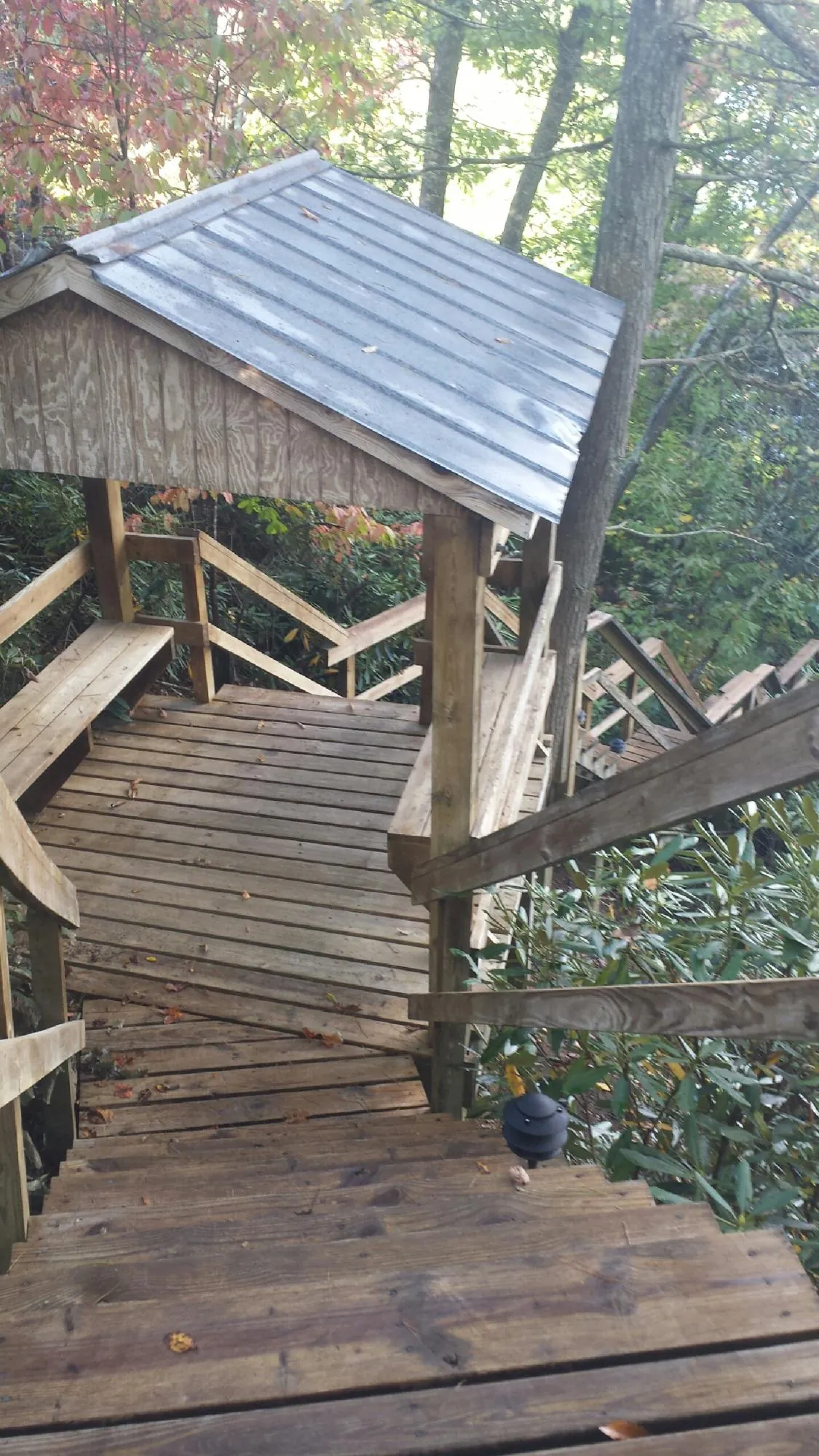 Metal roofed shelter over wooden steps on a wooded walkway — Skylight Repair & Installation work by our crew in Mansfield Center