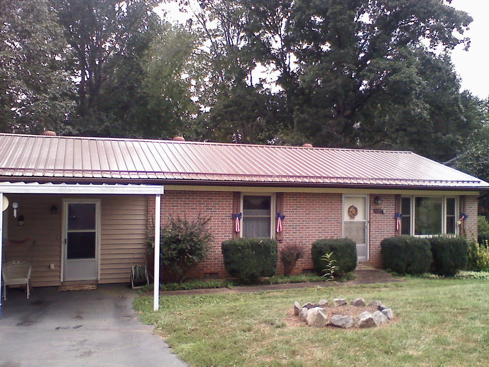 Bronze metal roof and carport on a brick ranch home — Roof Repair work by our crew in Mansfield Center